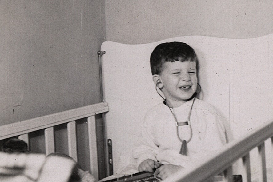 Jeff Blinder as a young boy in a crib with a stethoscope in his ears