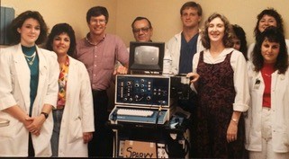 Doctor Jane Clayton to the right of ultrasound technology and surrounded by co workers