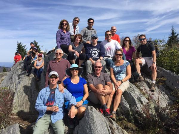 Large group of radiology residency program alumni sitting on boulders in the mountains of North Carolina